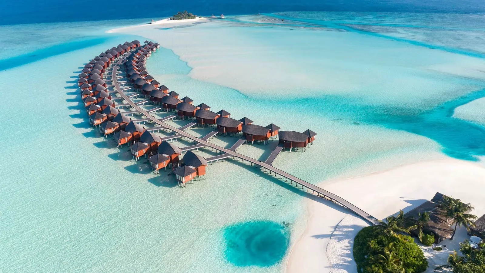 منظر جوي لمنتجع يضم فلل مائية وشاطئ — منتجع Anantara Dhigu Maldives Resort