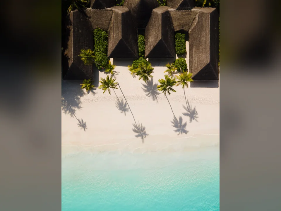 لقطة علوية لفلل الشاطئ وظلال النخيل في Sun Siyam Iru Veli