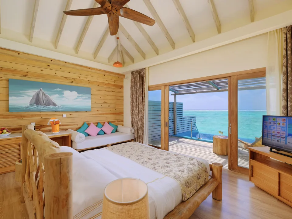 غرفة نوم بتصميم خشبي دافئ في You & Me Maldives